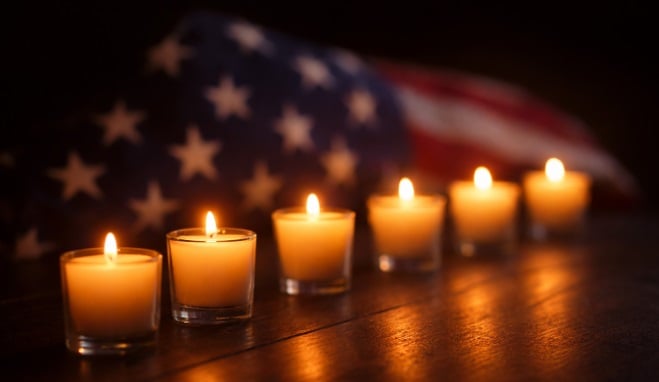 cremation services in Loudonville, NY candles glowing beside a folded American flag